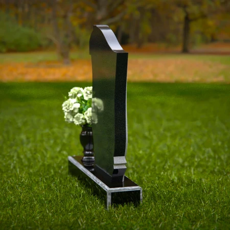 Traditional granite headstones with cross design and flower vase.