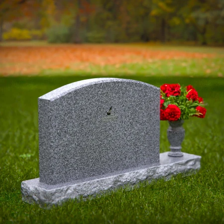 Waved granite headstones featuring floral vase tribute.