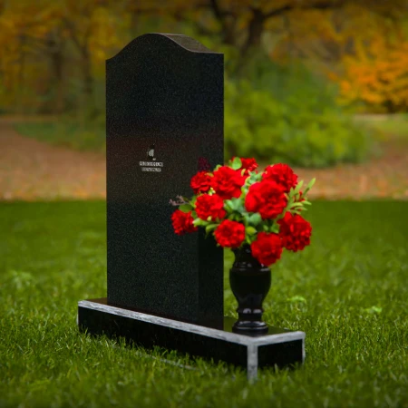 Classic granite headstones with arched top and flower vase.