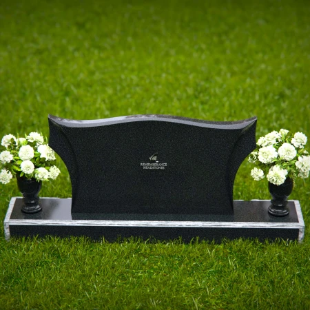 Elegant headstones with sculpted wave design and dual floral vases.