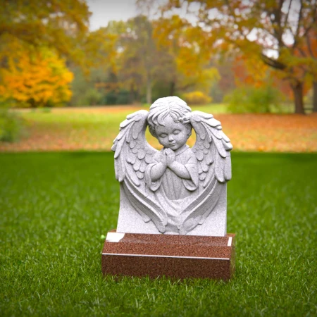 Reflective child tombstones carved with kneeling cherub angel
