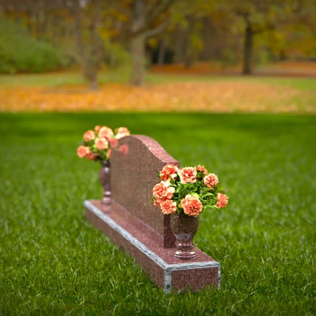 Artistic wave-top headstones with twin floral vases.