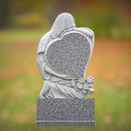 Heart-shaped gray granite headstone with angel design — a touching memorial tribute.