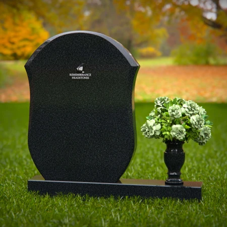 Unique granite headstones with rounded shield design and flower vase.