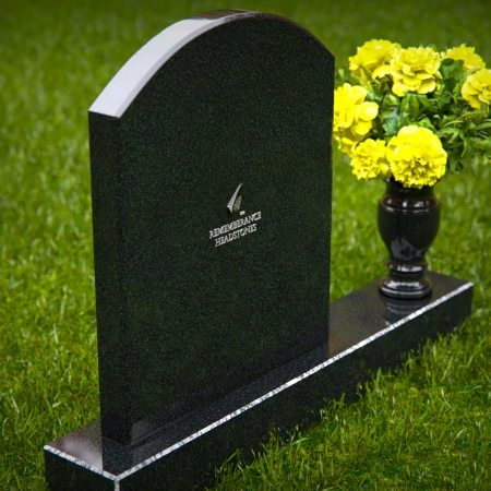 Classic arched granite headstones with polished vase tribute.
