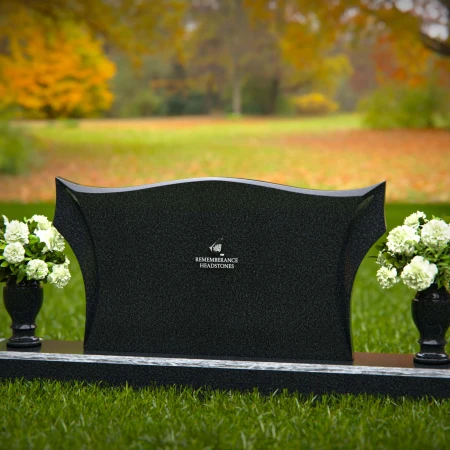 Elegant headstones with sculpted wave design and dual floral vases.