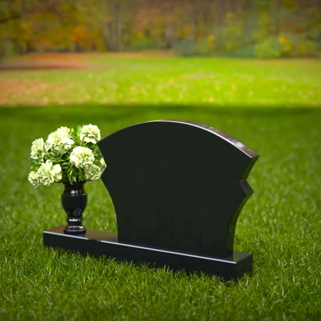 Unique headstones featuring artistic arch designs and floral vases.