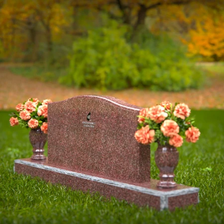 Artistic wave-top headstones with twin floral vases.