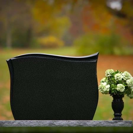 Contoured granite headstones with polished finish and flower vase.