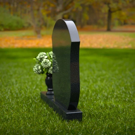Unique granite headstones with rounded shield design and flower vase.
