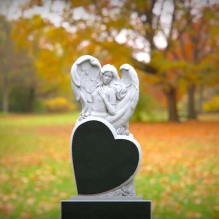 Peaceful angel rests over carved heart in symbolic headstones