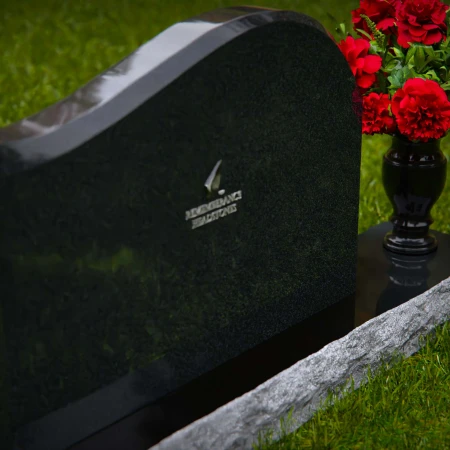 Modern waved granite headstones with flower vase for peaceful tribute.