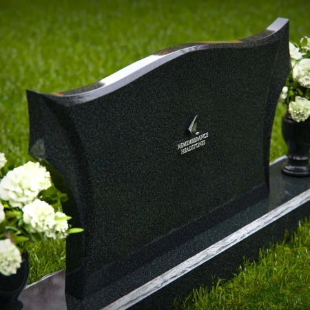 Elegant headstones with sculpted wave design and dual floral vases.