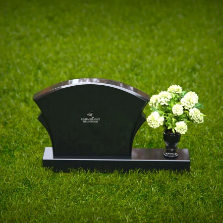 Unique headstones featuring artistic arch designs and floral vases.