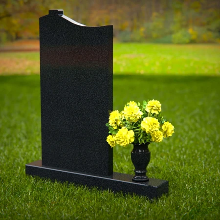 Upright granite headstones with cross design and flower vase.
