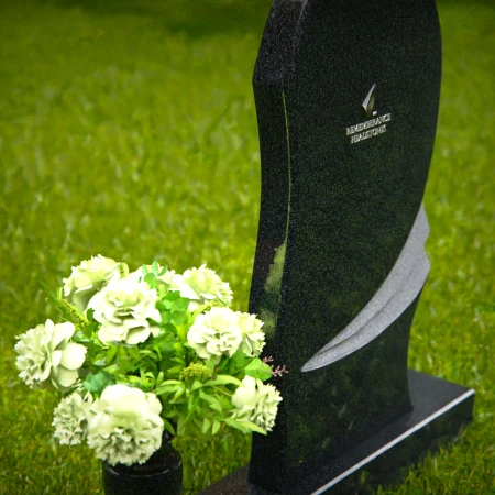 Contemporary headstones with curved artistic design and floral vase.
