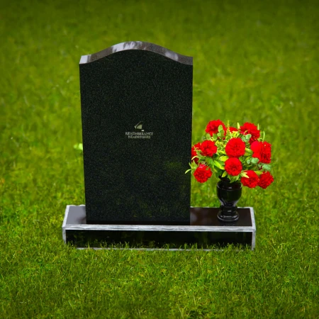 Classic granite headstones with arched top and flower vase.