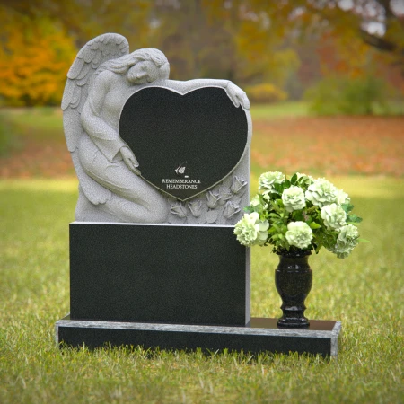 Granite angel heart headstones with floral vases for loving memorials.