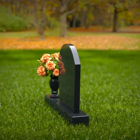 Classic arched granite headstones with single flower vase tribute.
