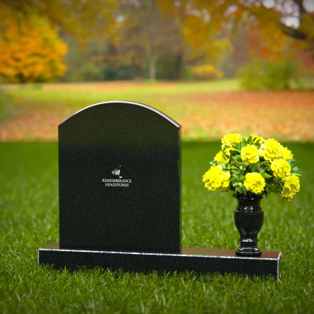 Classic arched granite headstones with polished vase tribute.