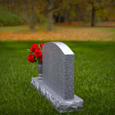 Waved granite headstones featuring floral vase tribute.
