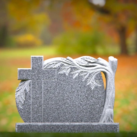 A carved cross and branching life tree define these headstone near me