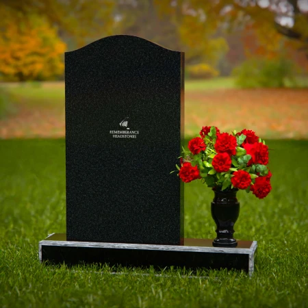 Classic granite headstones with arched top and flower vase.