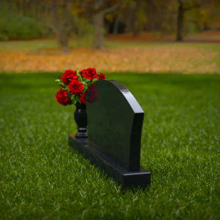 Contoured granite headstones with single flower vase for tribute.