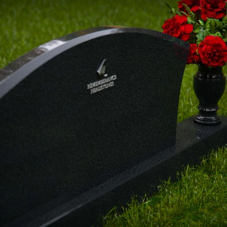 Contoured granite headstones with single flower vase for tribute.