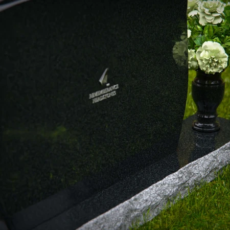 Contoured granite headstones with polished finish and flower vase.
