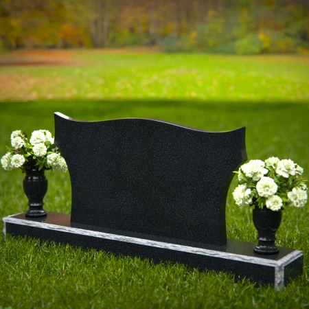 Elegant headstones with sculpted wave design and dual floral vases.