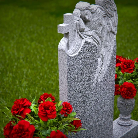 1911 - Angel Monument Embracing Cross with Floral Tributes