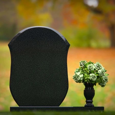 Unique granite headstones with rounded shield design and flower vase.