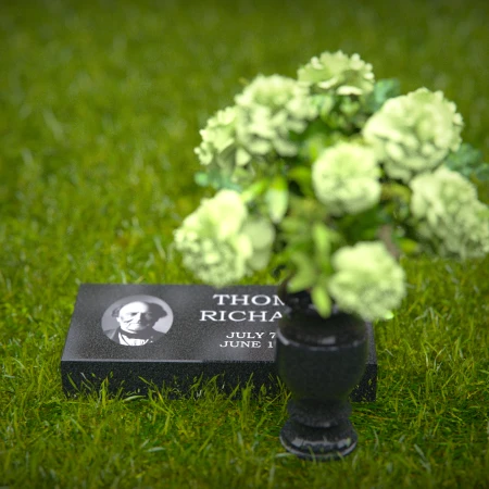 Compact headstones featuring photo inlays and floral vases for memorials.