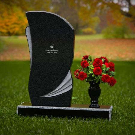 Modern headstones with artistic curves and a matching floral vase.