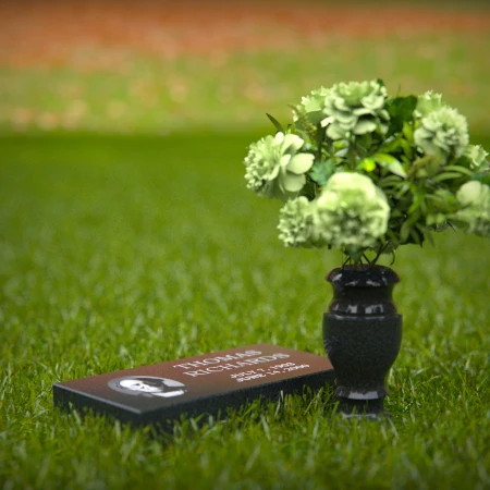 Compact headstones featuring photo inlays and floral vases for memorials.