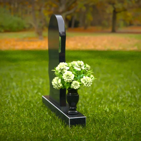 Contemporary headstones with curved artistic design and floral vase.