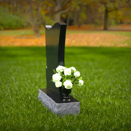 Elegant granite headstones with flowing contoured design and flower vase.