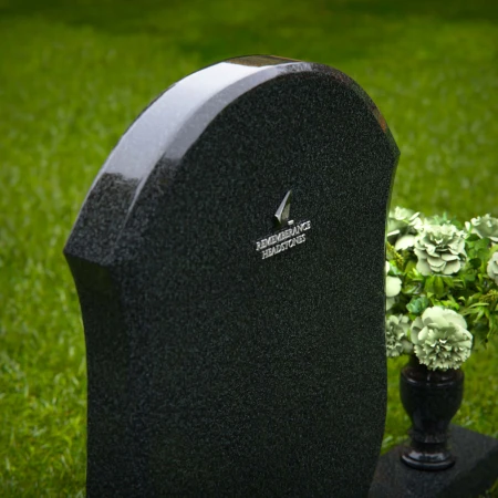 Unique granite headstones with rounded shield design and flower vase.