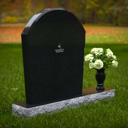 Arched granite headstones with elegant form and flower vase.