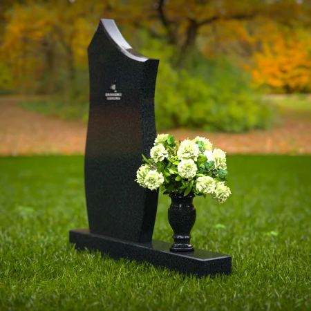 Modern contoured granite headstones with single flower vase.