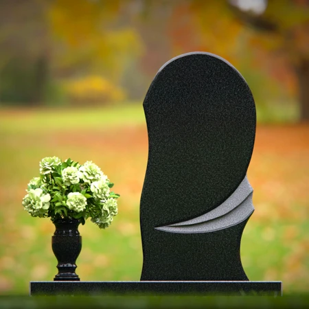 Contemporary headstones with curved artistic design and floral vase.