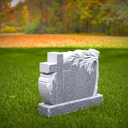 A carved cross and branching life tree define these headstone near me