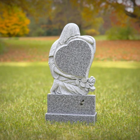Heart-shaped gray granite headstone with angel design — a touching memorial tribute.