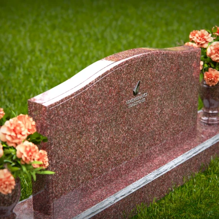 Artistic wave-top headstones with twin floral vases.