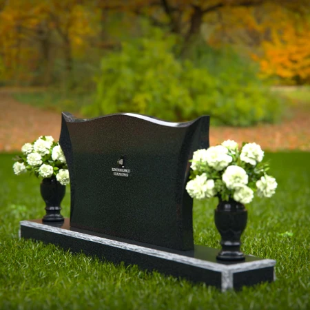 Elegant headstones with sculpted wave design and dual floral vases.