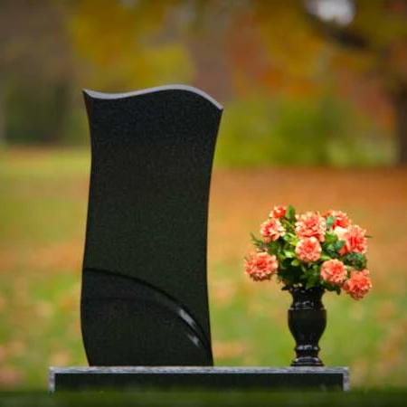 Modern waved granite headstones with elegant carved accents.