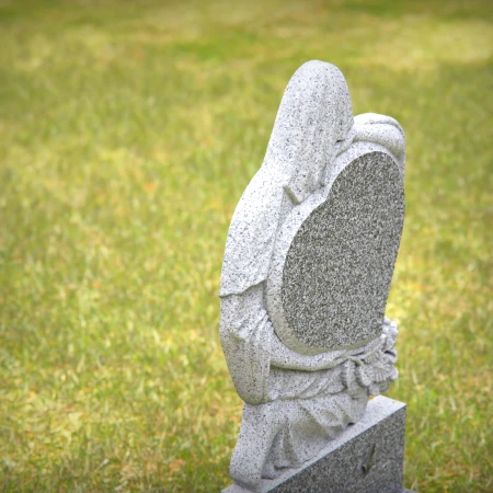 Heart-shaped gray granite headstone with angel design — a touching memorial tribute.