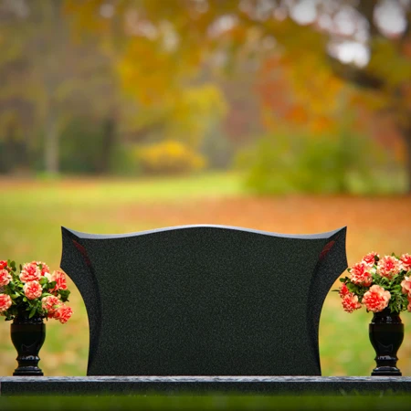 Elegant headstones with sculpted wave design and dual floral vases.