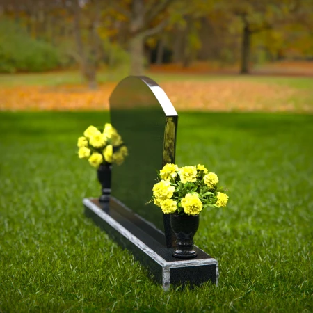 Waved granite headstones with dual flower vases for elegant tribute.